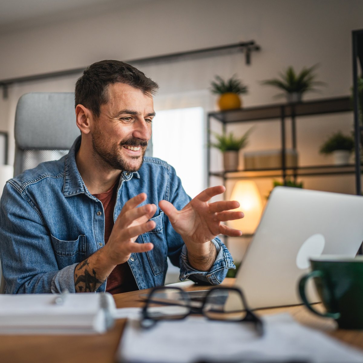 Adult man work on laptop and have video call meeting at home office