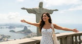 Woman with arms outstretched in front of Christ the Redeemer statue overlooking Rio de Janeiro bay