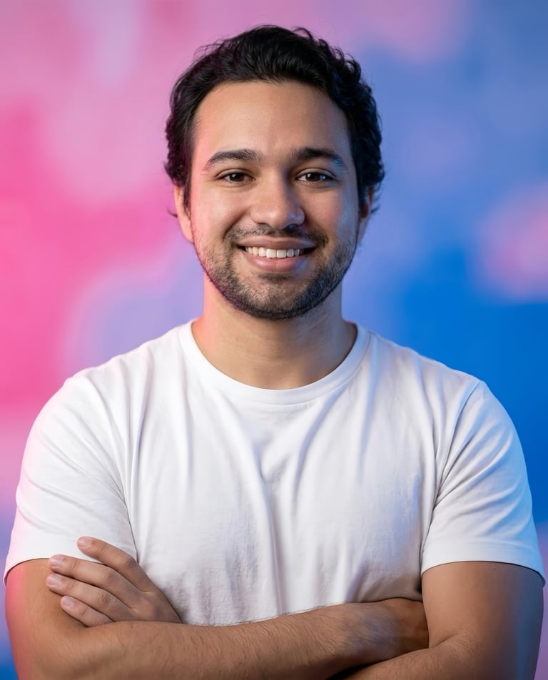 Portrait of a smiling man with dark hair wearing a white t-shirt against a pink and blue gradient background