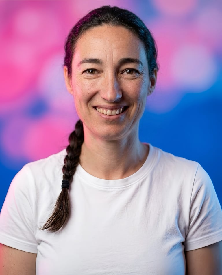 Woman with dark braided hair wearing a white t-shirt smiling at camera against a pink and blue gradient background