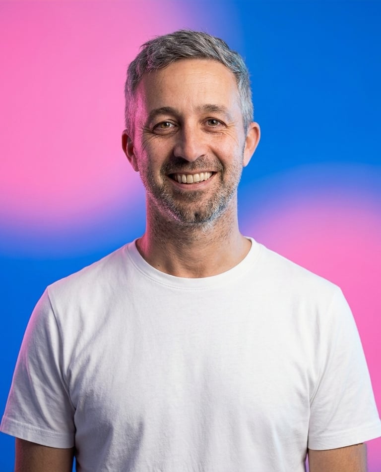 Smiling man with gray hair wearing a white t-shirt against a gradient pink and blue background
